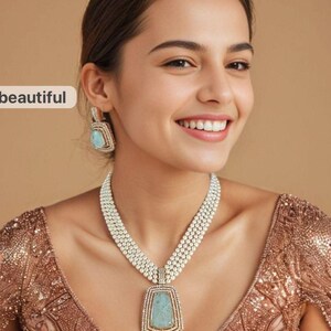 Puede incluir: Una mujer con un collar de perlas y pendientes a juego. El collar tiene un colgante grande y rectangular con una piedra azul claro. Los pendientes también tienen piedras azul claro. La mujer lleva un top dorado con lentejuelas.