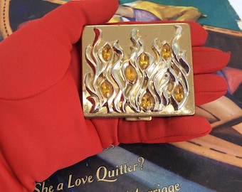 Polvos compactos vintage raros de Paul Flato con diseño de llamas enjoyadas.