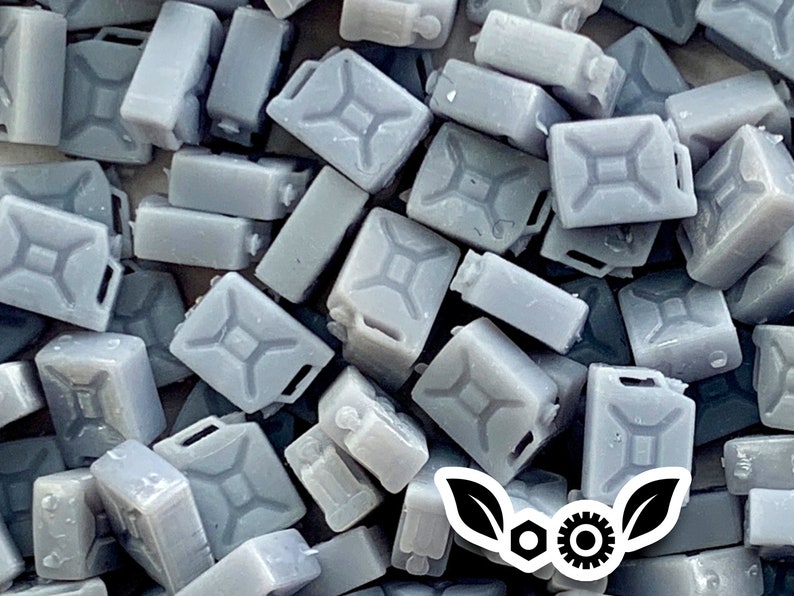 Op de afbeelding: Een grote stapel grijze plastic jerrycans, die vaak worden gebruikt voor het opslaan van vloeistoffen. De jerrycans hebben een kenmerkende rechthoekige vorm met een handvat bovenop.