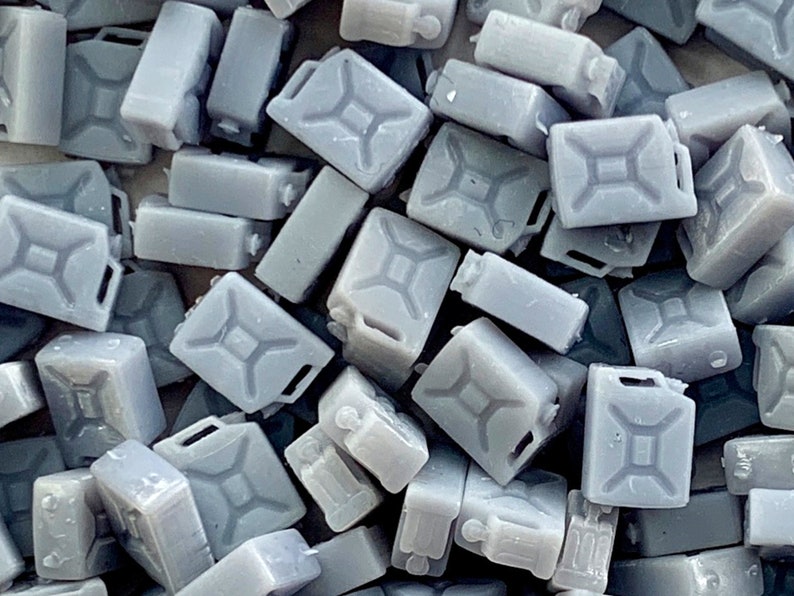 Op de afbeelding: Een close-up van een stapel grijze plastic jerrycans. De jerrycans zijn allemaal even groot en hebben dezelfde vorm, en ze zijn op elkaar gestapeld.