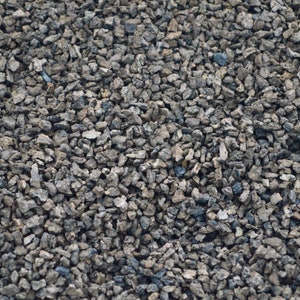 May include: A close-up of a textured surface covered in small, gray gravel.