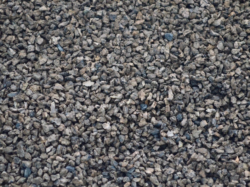 May include: A close-up of a textured surface covered in small, gray gravel.