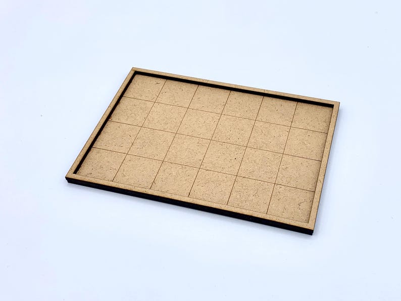 May include: A rectangular, light brown wooden tray with a grid pattern. The tray has a raised border and is divided into 25 equal squares. The wood has a natural, unfinished appearance.
