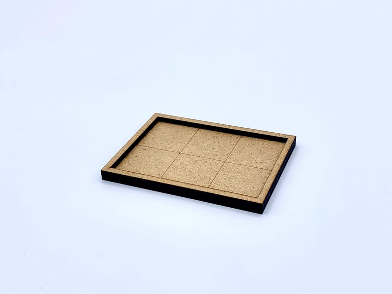 May include: A rectangular wooden tray with a dark brown border and a light brown interior divided into six equal squares. The tray is set against a white background.