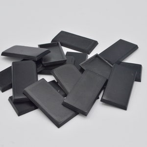 Pode incluir: Um monte de bases retangulares de plástico preto para figuras em miniatura.