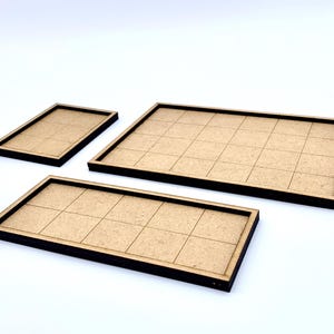 May include: Three wooden game board trays with grid patterns. The trays are rectangular with dark brown edges and a light brown interior. The sizes vary, with one small, one medium, and one large tray.