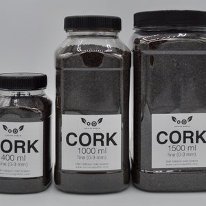 May include: Three clear plastic jars filled with dark brown cork granules. The jars are labeled "Cork" with different sizes: 400 ml, 1000 ml, and 1500 ml. The labels also indicate that the cork is "fine (0-3 mm)".
