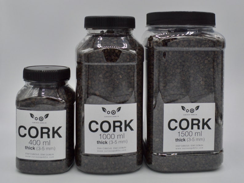 May include: Three clear plastic jars filled with brown cork bark pieces. The jars are labeled with the text "Cork" and the volume of cork bark in each jar: 400 ml, 1000 ml, and 1500 ml. The text also indicates the thickness of the cork bark pieces: 3-5 mm.