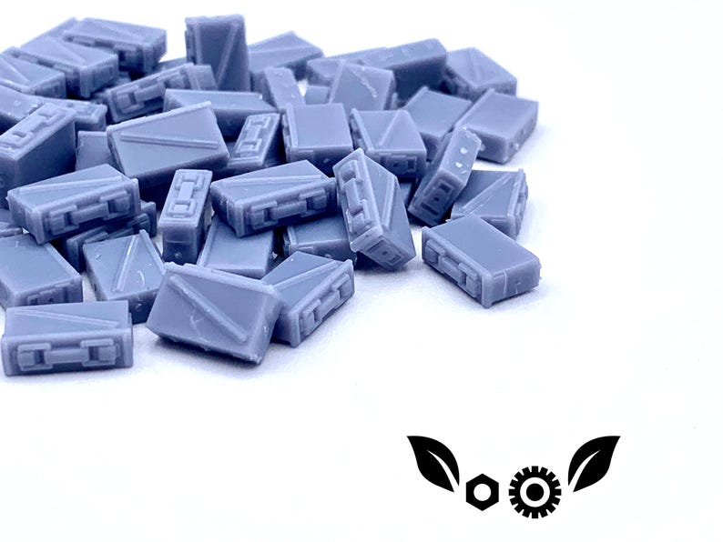 May include: A pile of small, gray, plastic boxes. The boxes are all the same size and shape, and they are arranged in a random order.