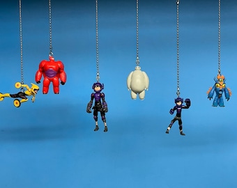 May include: A set of six colorful plastic figurines hanging from silver chains. The figurines include a yellow and black robot, a red and purple robot, a white robot, a purple and black robot, a blue and orange robot, and a blue robot with a red eye.