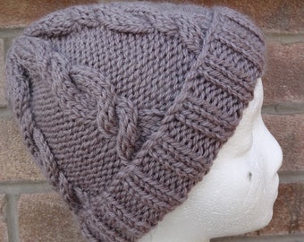 May include: A grey knitted beanie with a cable knit pattern. The beanie is on a white mannequin head.