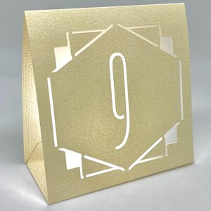 ART DECO Table Number LUMINARIES are made with sturdy card stock and sheer vellum paper. The numbers and modern design are cut out  so your battery tea lights can shine through.The glowing numbers make it easy for guests to find their table.