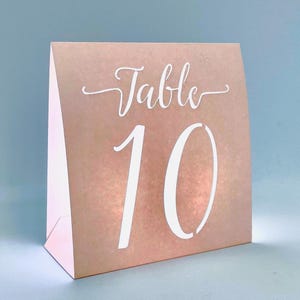 May include: A light pink table number card with the word "Table" and the number "10" in white.