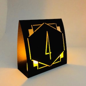 ART DECO Table Number LUMINARIES are made with sturdy card stock and sheer vellum paper. The numbers and modern design are cut out  so your battery tea lights can shine through.The glowing numbers make it easy for guests to find their table.