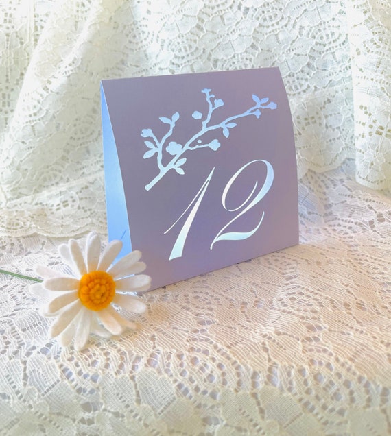 Cherry Blossom Table Number Luminaries made with card stock. The glow of the light through the cut out design brings romance to every table.