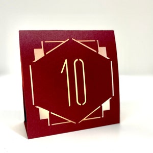 ART DECO Table Number LUMINARIES in are made with sturdy card stock and sheer vellum paper. The numbers and modern design are cut out  so your battery tea lights can shine through.The glowing numbers make it easy for guests to find their table.