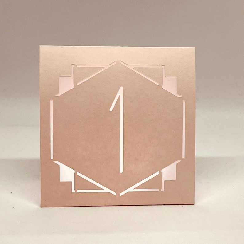 ART DECO Table Number LUMINARIES are made with sturdy card stock and sheer vellum paper. The numbers and modern design are cut out  so your battery tea lights can shine through.The glowing numbers make it easy for guests to find their table.