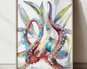 May include: Watercolor painting of an octopus with red, blue, and yellow hues, surrounded by green and yellow aquatic plants. The artwork is framed in a light-colored wooden frame, leaning against a white wall.