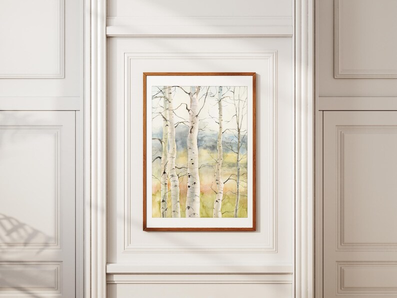 May include: A framed watercolor painting of birch trees with white bark and delicate branches. The artwork features a soft color palette of greens, yellows, and blues, creating a serene forest scene. The frame is a warm brown.