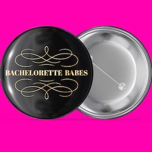 Może przedstawiać: Czarny guzik z złotym wzorem i tekstem "BACHELORETTE BABES". Guzik ma srebrny tył z szpilką.