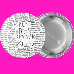 May include: A white button with a black and white design that says "Arrest the cops who killed Breonna Taylor" repeated many times.