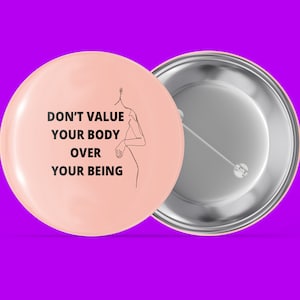 Può includere: Un bottone rosa con il testo "DON'T VALUE YOUR BODY OVER YOUR BEING" e un disegno a linea di un corpo umano.
