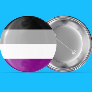 May include: A round button with a black, gray, white, and purple striped design. The back of the button is silver with a pin.