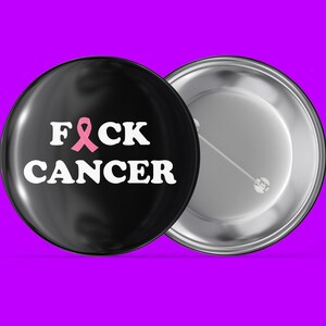 May include: Black button with a white "F**K CANCER" message and a pink ribbon.