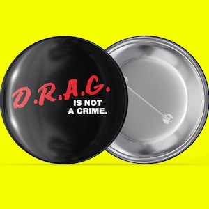 May include: A black button with a white background and red text that reads "D.R.A.G. IS NOT A CRIME."