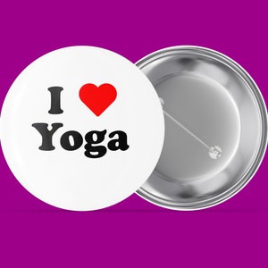 Könnte beinhalten: Weißer Knopf mit einem roten Herzen und dem Text "I love Yoga" in Schwarz. Die Rückseite des Knopfes ist silber.