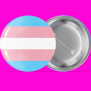 May include: A round button with a transgender pride flag design. The button is silver with a pin on the back.