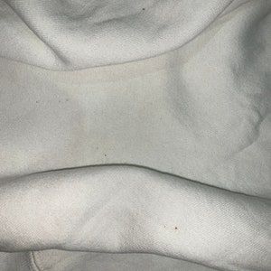 Pu&ograve; includere: Tessuto bianco con alcune piccole macchie marroni.