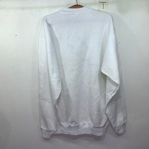 Pu&ograve; includere: Felpa bianca a maniche lunghe con collo rotondo.