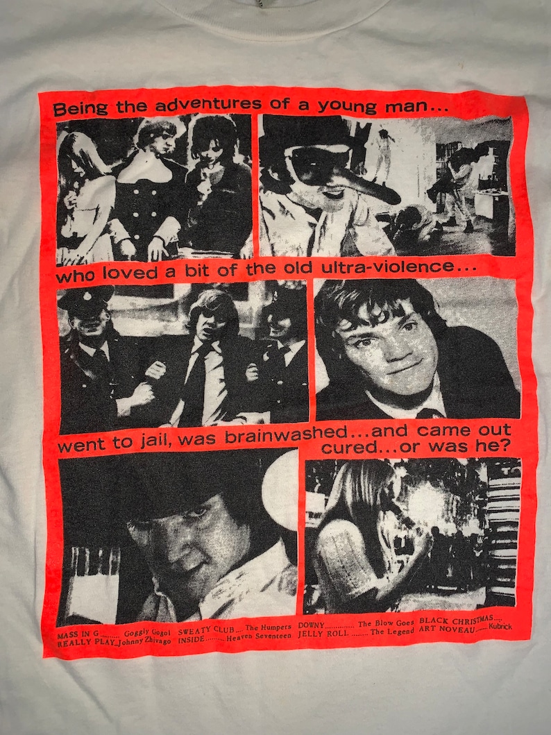 May include: A white t-shirt with a red graphic print of a collage of black and white images. The text on the graphic reads "Being the adventures of a young man... who loved a bit of the old ultra-violence... went to jail, was brainwashed...and came out cured...or was he?"  The bottom of the graphic lists the names of movies and directors.