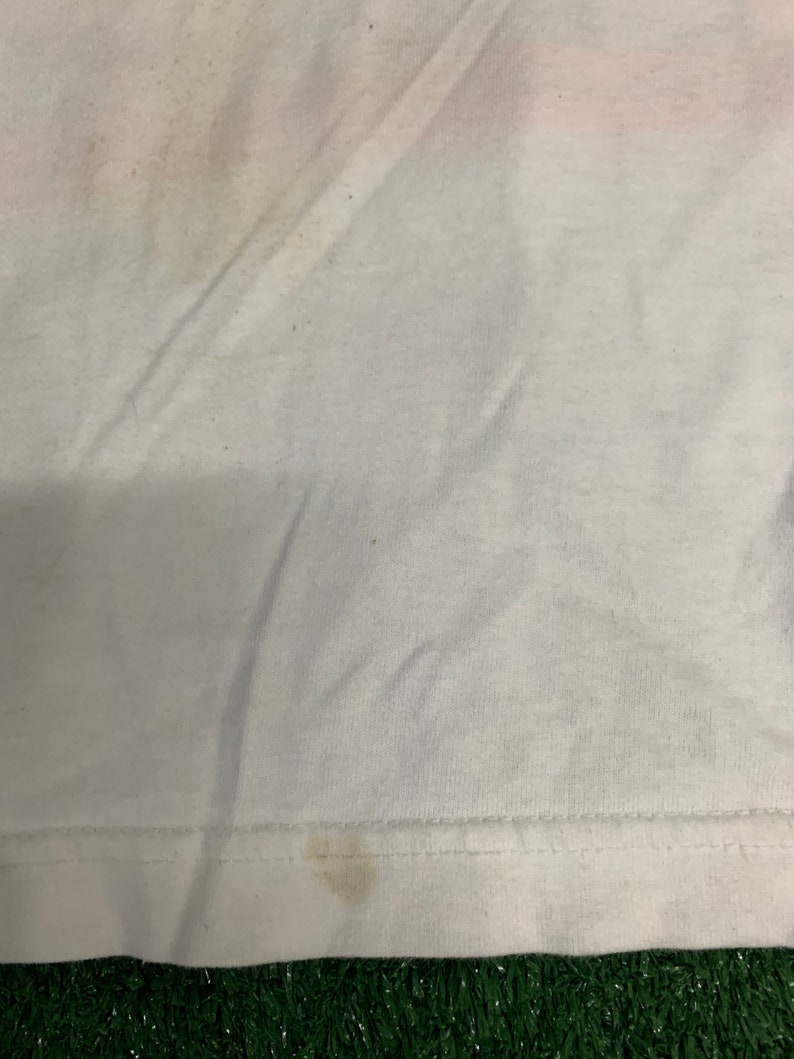 May include: A white t-shirt with a few small stains. The shirt is made of a soft, comfortable material.