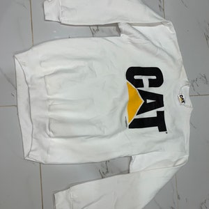 Pu&ograve; includere: Felpa bianca a maniche lunghe con logo CAT nero e giallo.