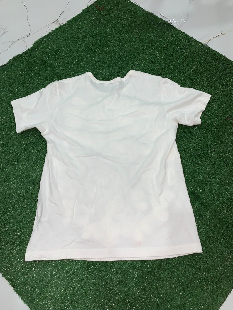 Pu&ograve; includere: Una maglietta bianca semplice a maniche corte e collo rotondo.