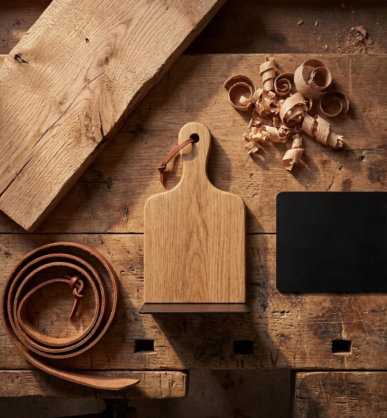 a wooden table with various items on it, including a wooden cutting board, a leather belt, and some wood shavings.