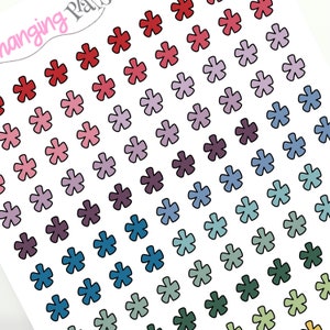 May include: A sheet of colorful star stickers in a gradient of red, pink, purple, blue, green, and yellow. The stars are outlined in black and have a slightly irregular shape.