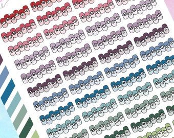 May include: A sheet of colorful nail stickers with a gradient design. Each sticker features a white circle with the letters "M, W, T, F, S, S" inside. The stickers are arranged in rows and columns.