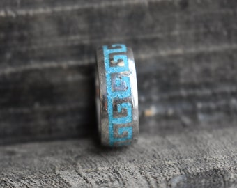 May include: A silver ring with a blue turquoise inlay in a Greek key pattern.