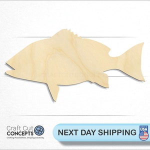 May include: A wooden cutout of a fish in a light brown color. The fish is facing left and has a large mouth. The cutout is made of plywood and is ready to be painted or stained.
