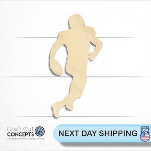 May include: A wooden cutout of a football player in a running pose, holding a football. The cutout is unpainted and has a natural wood color.