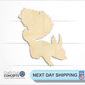 May include: A wooden cutout of a squirrel with a bushy tail. The cutout is made of natural wood and has a light brown color.