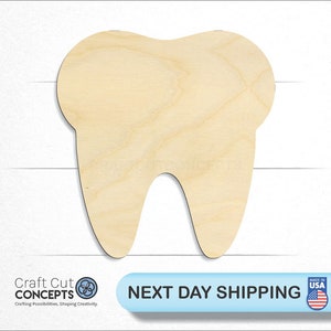 May include: A wooden cutout of a tooth, featuring a natural wood grain finish. The tooth shape is detailed with roots and a crown. The image includes the text "Craft Cut Concepts" and "Next Day Shipping".