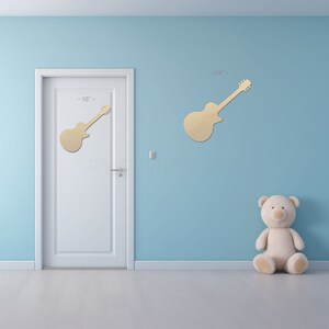 Guitar Shape sign shapes on a door and wall to view the scale.