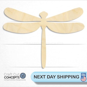 May include: A wooden dragonfly cutout, unpainted, with a natural wood color. The dragonfly is in flight with its wings spread out.