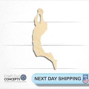 May include: Wooden cutout of a basketball player in mid-air, about to shoot the ball. The cutout is unpainted and has a natural wood color.