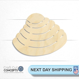 May include: A wooden cutout of a seashell with a layered design. The seashell is light brown and has a smooth surface.