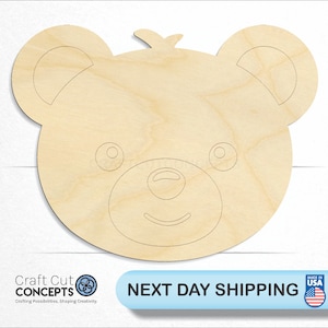 May include: Unfinished wooden bear head cutout. The bear has a simple smile and two eyes.